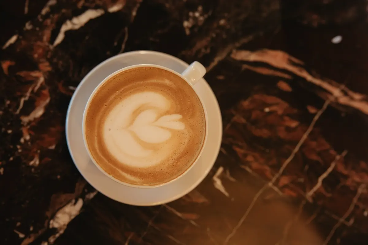 Latte con arte sobre mesa de mármol