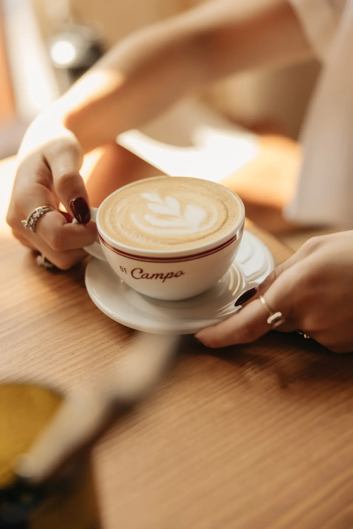 Latte servido en taza De Campo sobre la barra