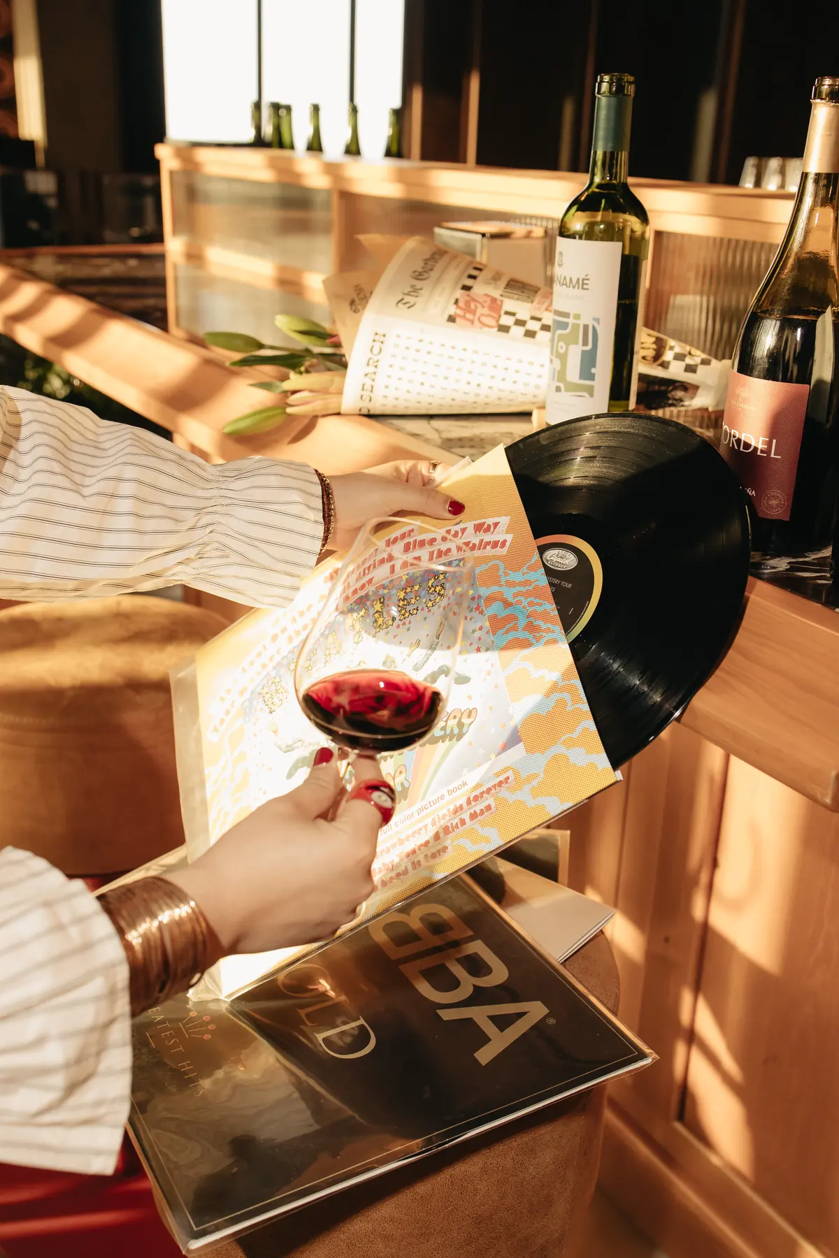 Copa de vino tinto junto a un vinilo